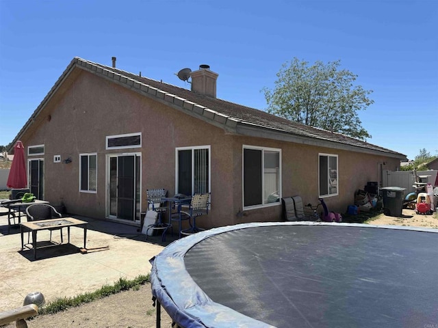 1255 Duckweed Trl, Campo, CA 91906 - rear view of house featuring a chimney, stucco siding, a patio, and a trampoline