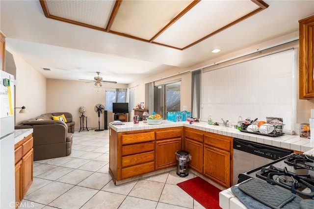 9656 Pebble Brook Dr, Moreno Valley, CA 92557 - kitchen with open floor plan, tile countertops, a peninsula, a ceiling fan, and brown cabinetry