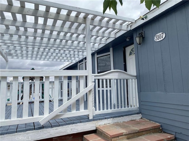 property entrance featuring a pergola and a deck