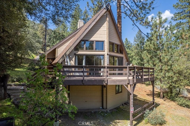 15616 San Moritz Dr, Pine Mountain Club, CA 93222 - rear view of house featuring a chimney, a deck, and an attached garage