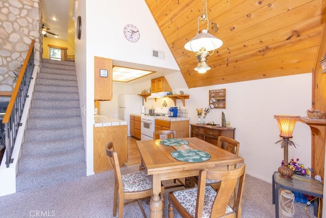 15616 San Moritz Dr, Pine Mountain Club, CA 93222 - dining space with light carpet, stairs, and high vaulted ceiling