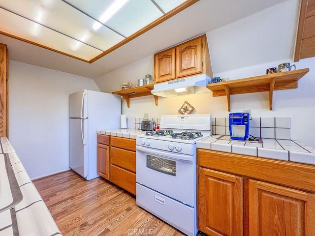 15616 San Moritz Dr, Pine Mountain Club, CA 93222 - kitchen with open shelves, white appliances, under cabinet range hood, tile counters, and light wood-style floors