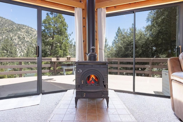15616 San Moritz Dr, Pine Mountain Club, CA 93222 - sunroom / solarium featuring a wood stove, a mountain view, and healthy amount of natural light