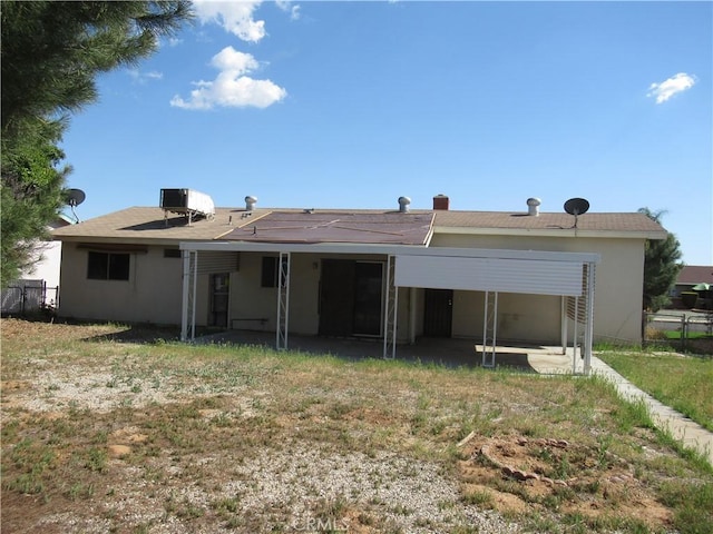 rear view of property featuring fence, central air condition unit, and stucco siding