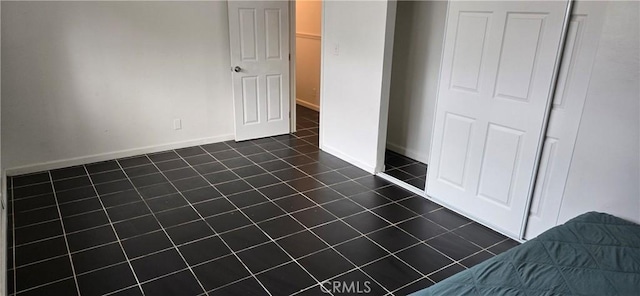 9715 La Docena Ln, Pico Rivera, CA 90660 - unfurnished bedroom featuring dark tile patterned flooring and baseboards
