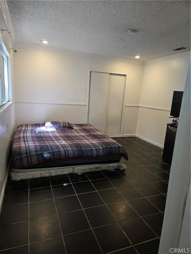 9715 La Docena Ln, Pico Rivera, CA 90660 - bedroom with dark tile patterned flooring, a textured ceiling, a closet, recessed lighting, and ornamental molding