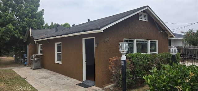 9715 La Docena Ln, Pico Rivera, CA 90660 - view of home's exterior with stucco siding, a patio, and roof with shingles