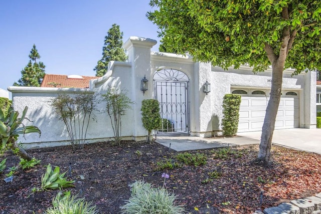 3424 Calle Azul Unit A, Laguna Woods, CA 92637 - view of front of home with concrete driveway, stucco siding, and a garage