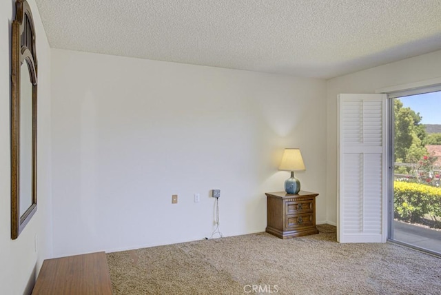 3424 Calle Azul Unit A, Laguna Woods, CA 92637 - unfurnished bedroom featuring access to outside, a textured ceiling, and carpet floors
