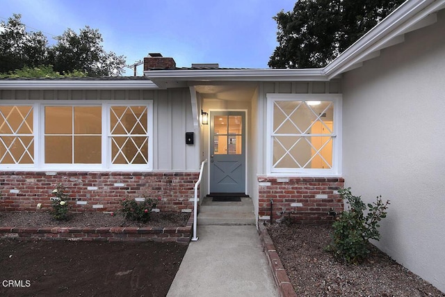 doorway to property featuring board and batten siding and a chimney