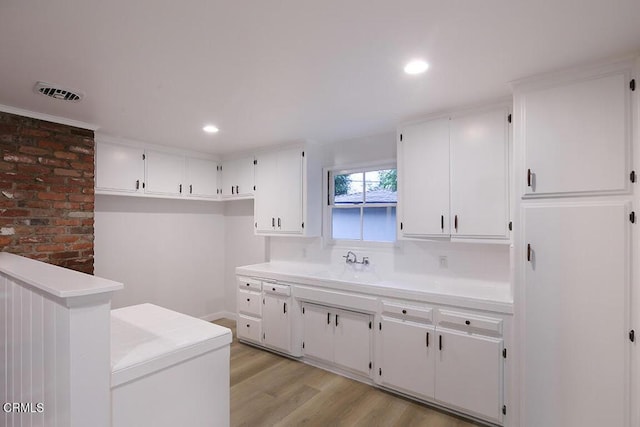 bathroom featuring wood finished floors, a sink, and recessed lighting