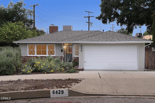 ranch-style house with a chimney, brick siding, a garage, and board and batten siding