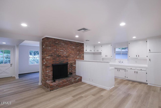 6429 Creemore Ln, Tujunga, CA 91042 - kitchen featuring white cabinetry, light wood-style flooring, recessed lighting, a fireplace, and light countertops