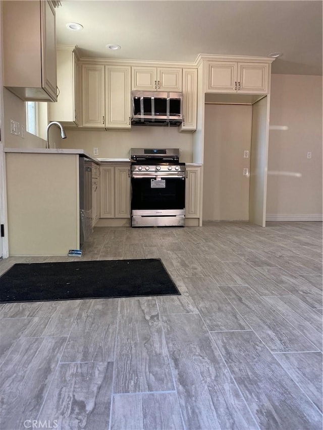 1727 W Santa Ana Blvd, Santa Ana, CA 92703 - kitchen featuring appliances with stainless steel finishes, cream cabinetry, light wood-style floors, and light countertops
