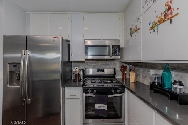 kitchen featuring appliances with stainless steel finishes, dark countertops, white cabinets, and decorative backsplash