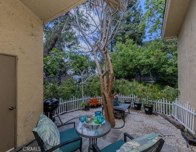 view of patio featuring outdoor dining space, a fenced backyard, and view of scattered trees
