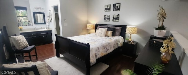bedroom featuring dark wood finished floors and a sink