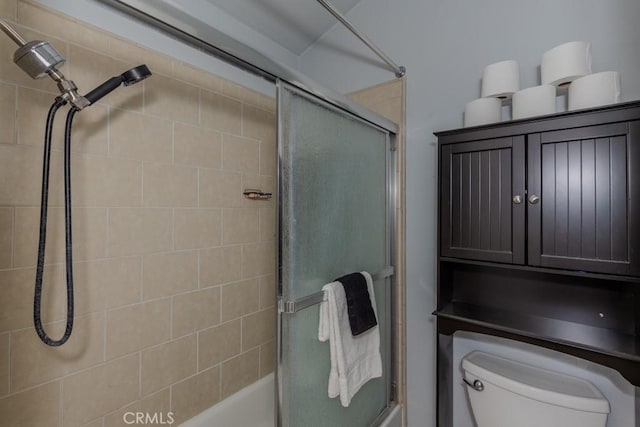 full bathroom with combined bath / shower with glass door and toilet
