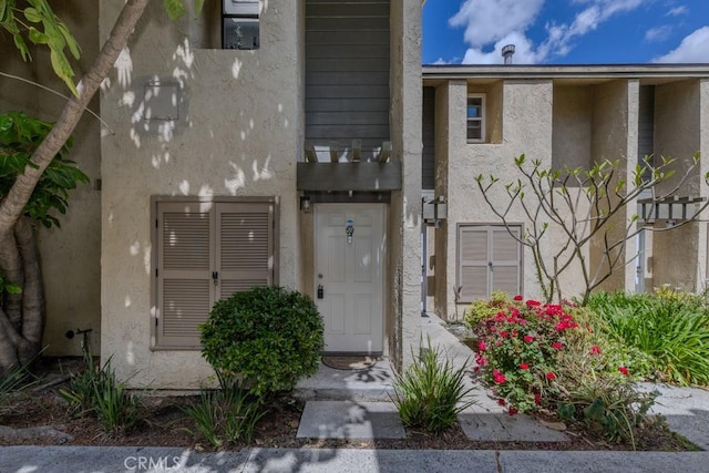 entrance to property featuring stucco siding