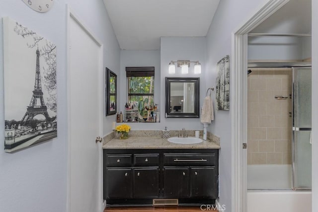 bathroom with shower / bath combination with glass door and vanity