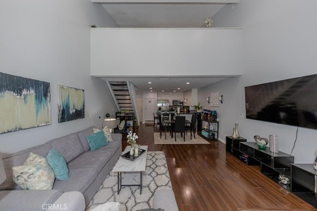 living room featuring stairway, wood finished floors, and high vaulted ceiling