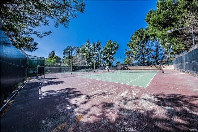 view of tennis court featuring fence