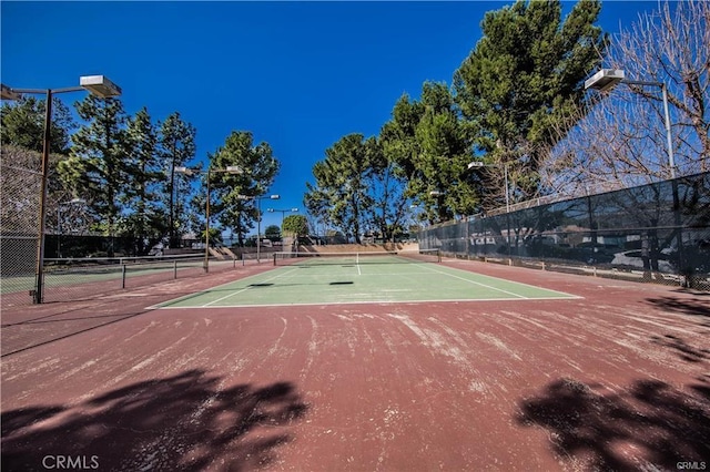 view of tennis court featuring fence