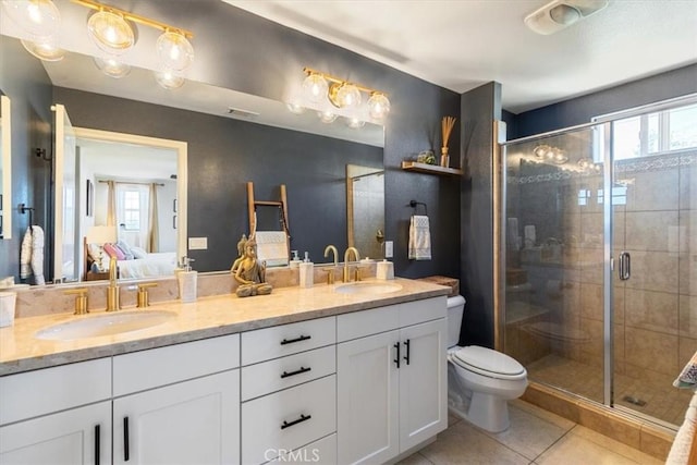 ensuite bathroom featuring healthy amount of natural light, tile patterned flooring, double vanity, and a stall shower