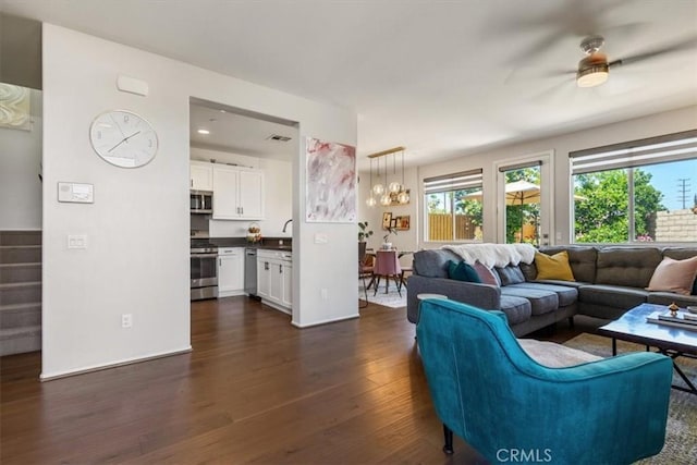 living area featuring dark wood finished floors and ceiling fan
