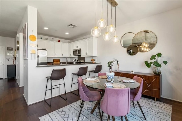 dining room featuring dark wood-type flooring, baseboards, and recessed lighting