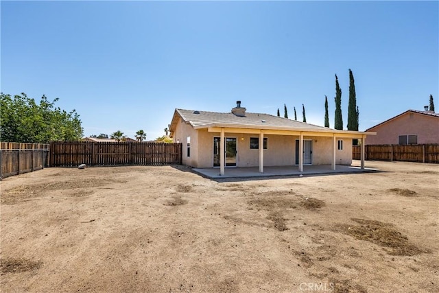 7728 Balsa Ave, Yucca Valley, CA 92284 - rear view of house featuring a patio area, a fenced backyard, stucco siding, and a chimney