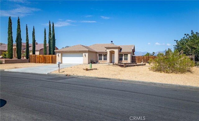 7728 Balsa Ave, Yucca Valley, CA 92284 - ranch-style home featuring a garage, stucco siding, driveway, and a tile roof