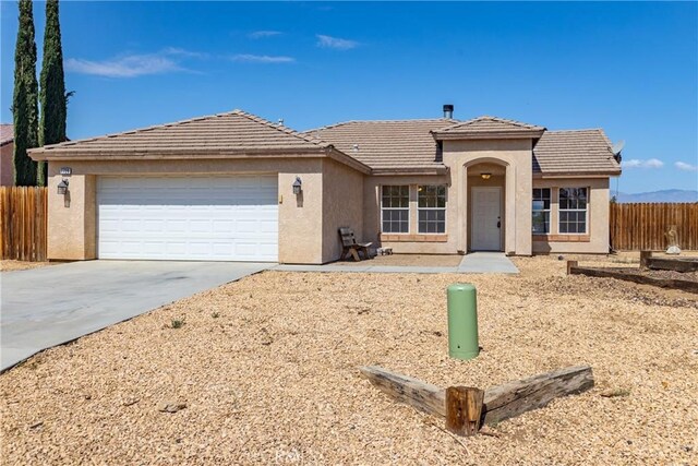 7728 Balsa Ave, Yucca Valley, CA 92284 - view of front of property with a garage, concrete driveway, stucco siding, and a tiled roof