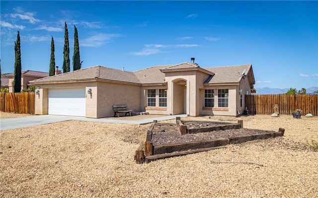 7728 Balsa Ave, Yucca Valley, CA 92284 - view of front of home with a tile roof, stucco siding, an attached garage, and driveway