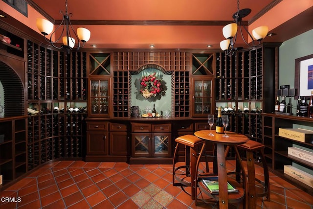 wine area featuring crown molding, tile patterned flooring, and a chandelier