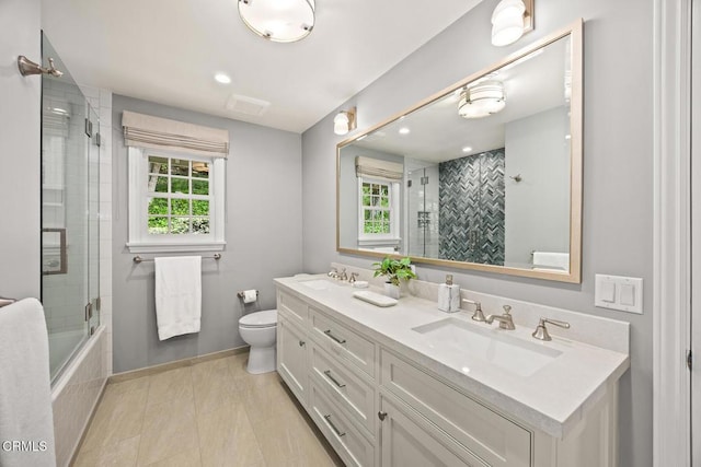 bathroom featuring toilet, double vanity, baseboards, and tiled shower / bath combo