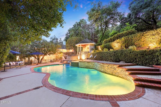 pool at dusk featuring a patio area and a fenced backyard