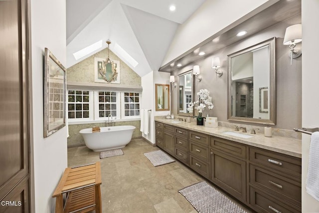 bathroom with vaulted ceiling, a soaking tub, double vanity, and recessed lighting