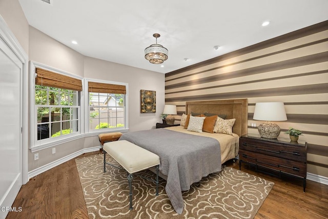bedroom featuring baseboards, wood finished floors, and recessed lighting