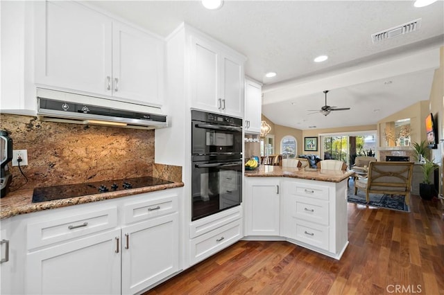 22299 San Joaquin Dr W, Canyon Lake, CA 92587 - kitchen featuring black appliances, under cabinet range hood, a peninsula, vaulted ceiling, and white cabinets