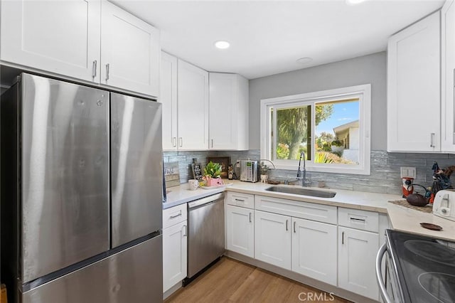 3660 Vista Campana N Unit 11, Oceanside, CA 92057 - kitchen with stainless steel appliances, a sink, white cabinets, tasteful backsplash, and recessed lighting