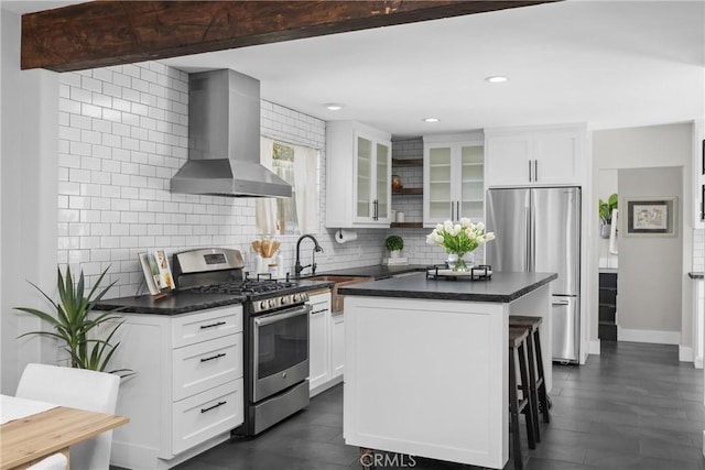 555 E Branch St, Arroyo Grande, CA 93420 - kitchen featuring appliances with stainless steel finishes, wall chimney exhaust hood, tasteful backsplash, dark countertops, and a center island