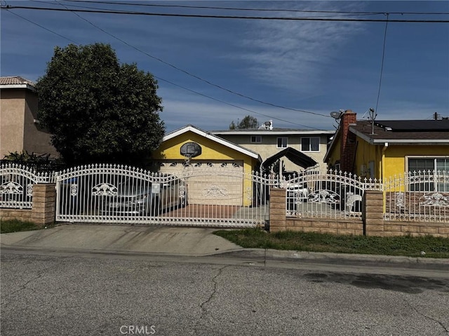 12145 Wanda St, El Monte, CA 91732 - view of front of property with a fenced front yard, a garage, a gate, stucco siding, and driveway