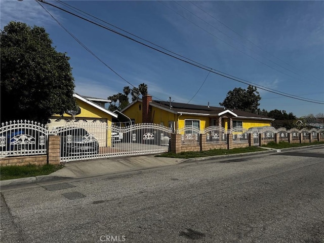 12145 Wanda St, El Monte, CA 91732 - view of front of home with a fenced front yard, an attached garage, roof mounted solar panels, driveway, and a gate
