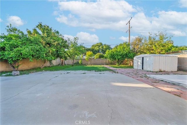 view of patio featuring a fenced backyard, a storage unit, and an outdoor structure
