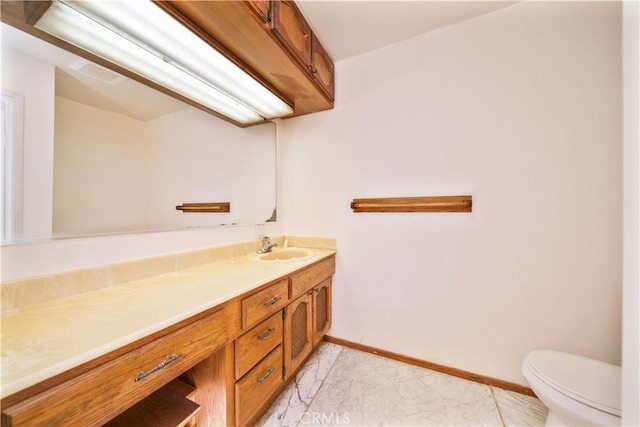 bathroom with vanity, toilet, and baseboards