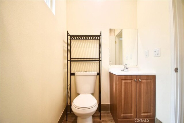 bathroom with vanity, toilet, and baseboards