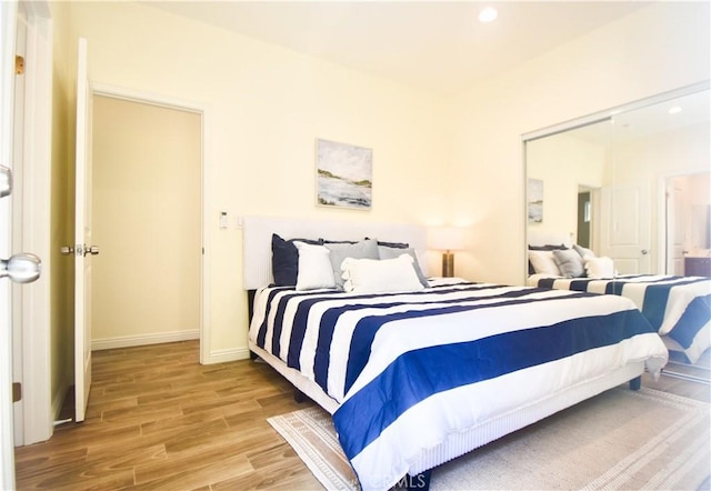 bedroom featuring wood finished floors, recessed lighting, and baseboards