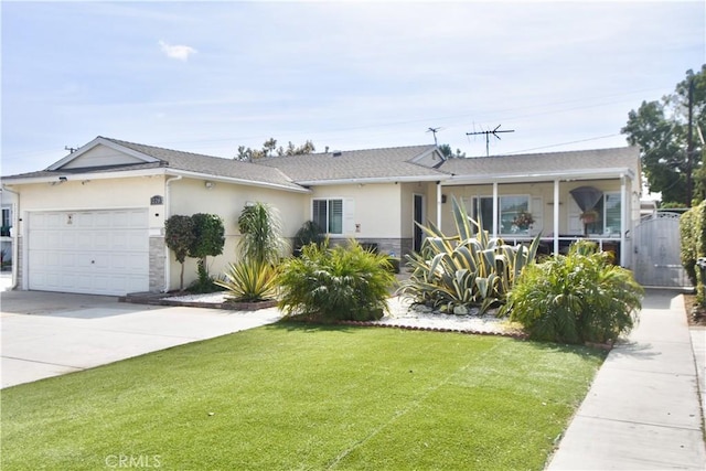 single story home featuring stucco siding, a front yard, an attached garage, and driveway