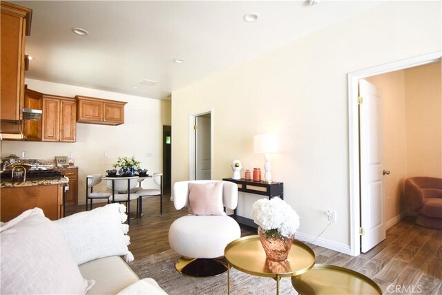 living area with wood finished floors, recessed lighting, and baseboards